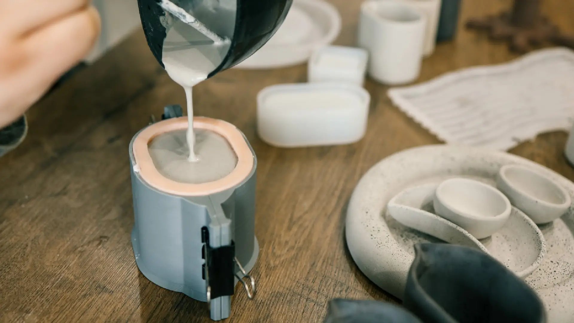 Eine Person gießt Gips in einer Form aus Silikon. Eine Person gießt Gips in einer Form aus Silikon.